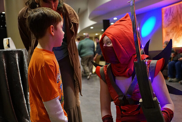 A Star Wars cosplayer talking with a child in The Lincoln Center lobby.