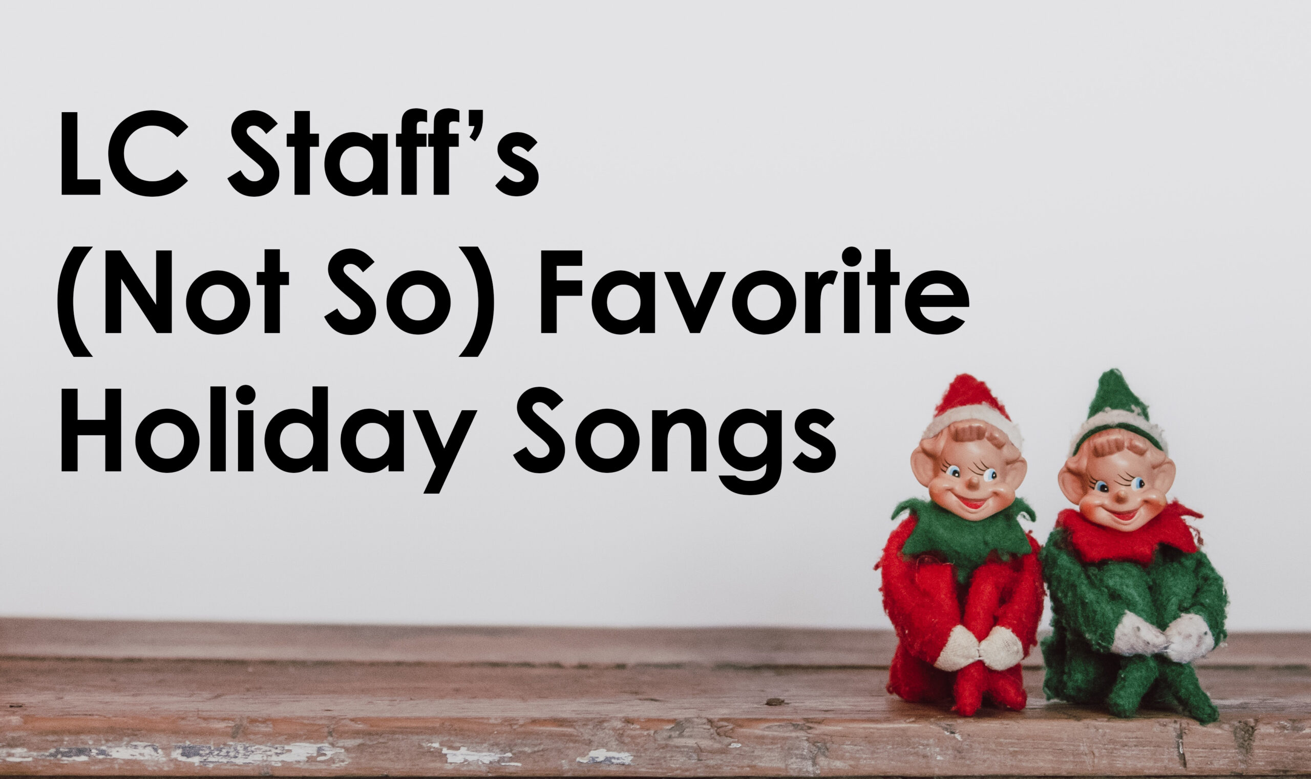 Two toy elevs sitting on a shelf with the words "LC Staff's (Not So) Favorite Holiday Songs."