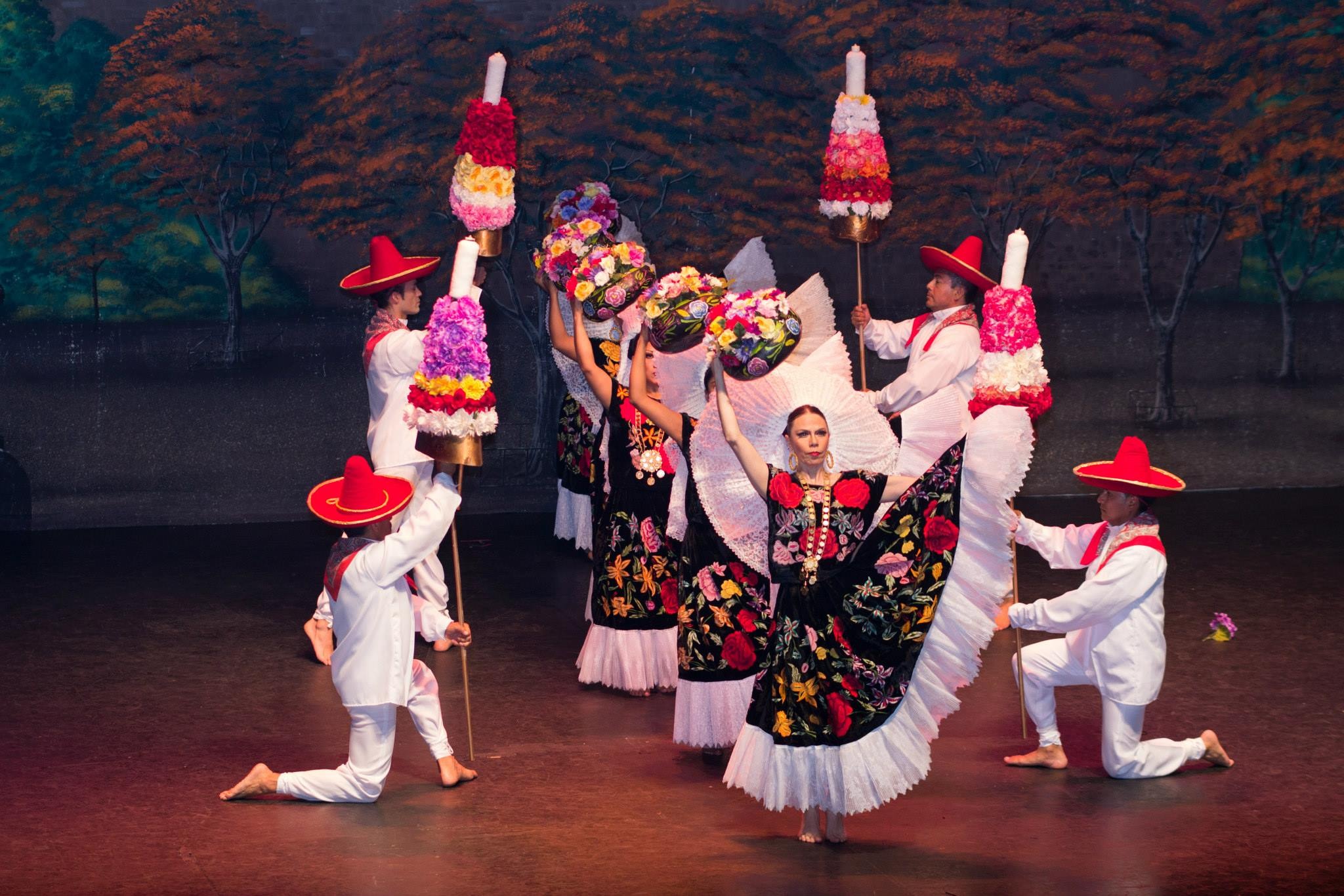 A traditional dance that features flowers on poles, colorful dresses, and a basket of flowers above each dancers' head.