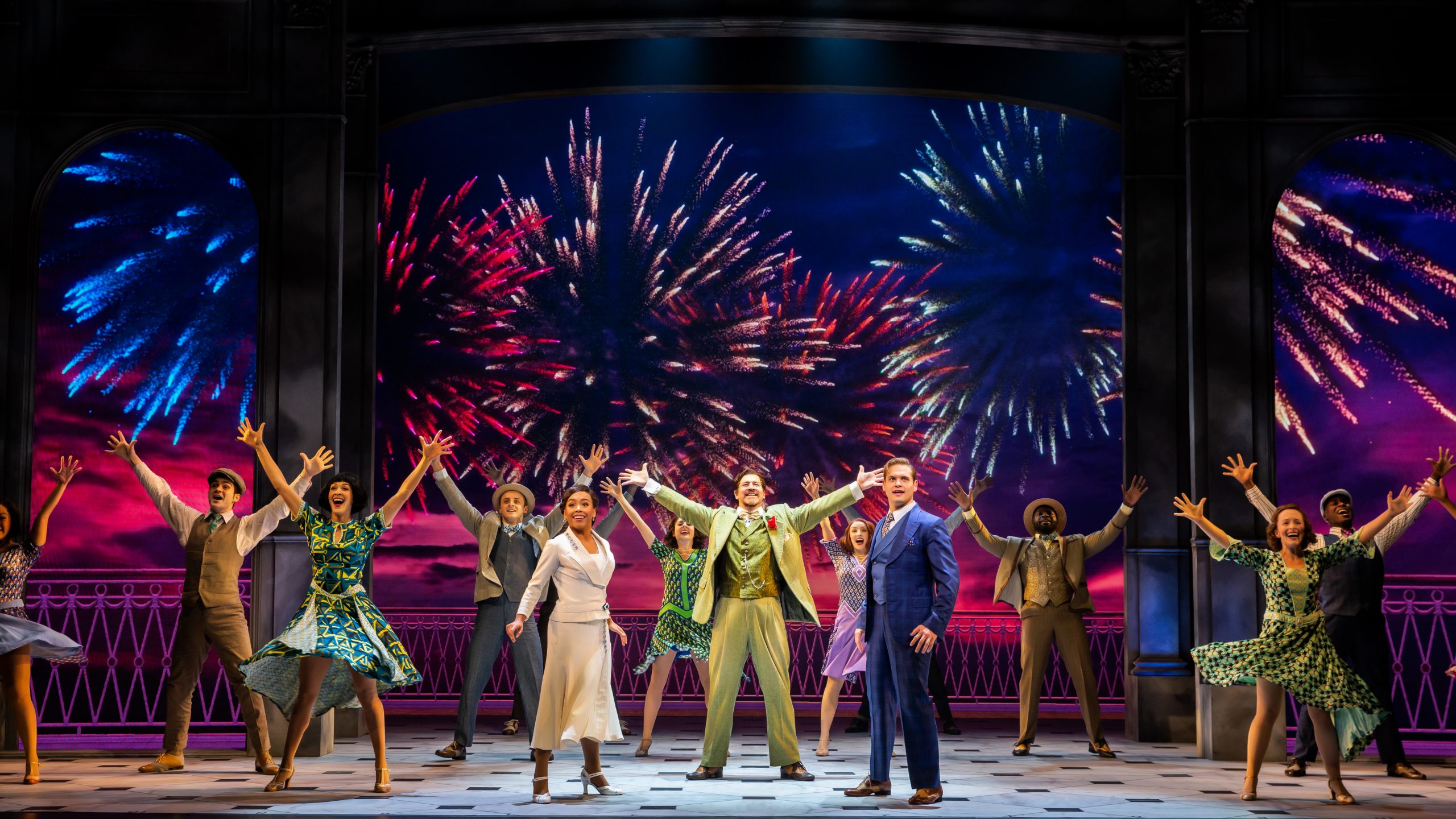 People on stage with a firework background