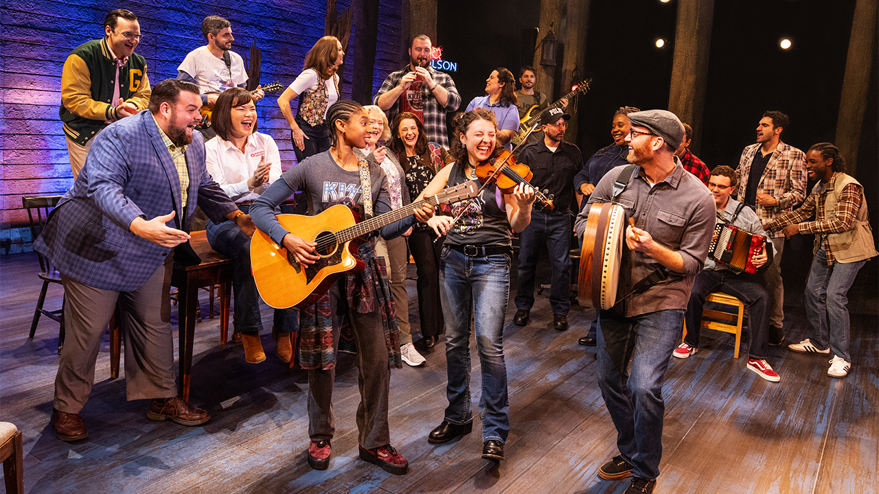 The full cast of Come From Away singing happily.