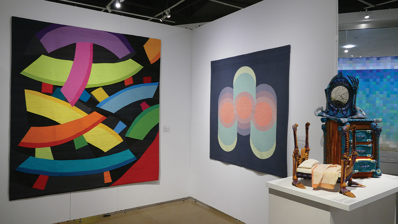 A photo of three different quilts in the exhibit.