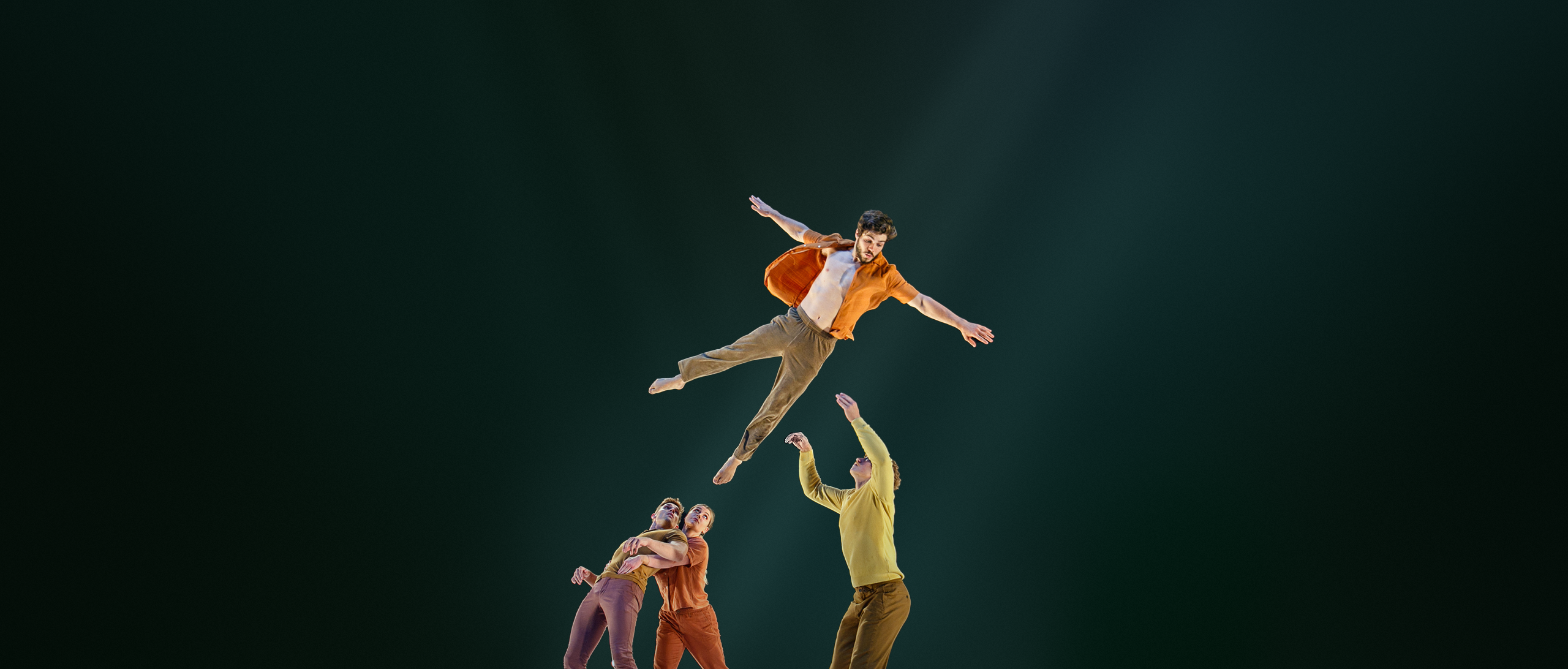 A man in an orange shirt soars through the air while others dance.