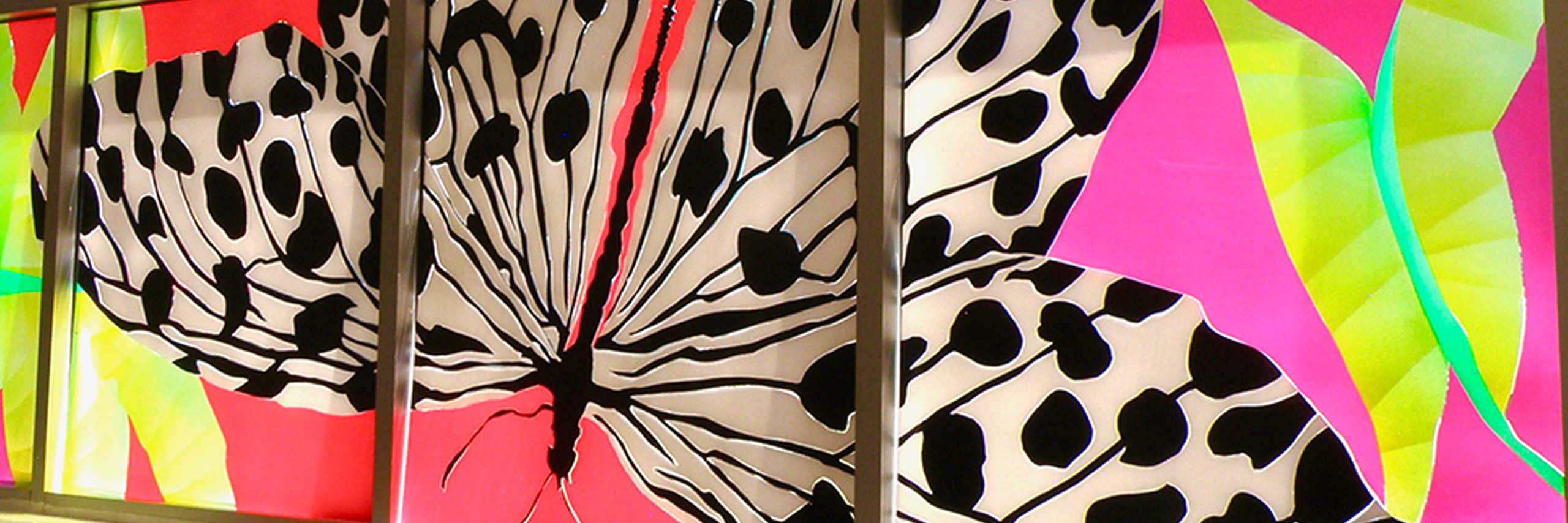 multiple canvases form a single art piece of a black and white butterfly set against a neon pink and yellow abstract background