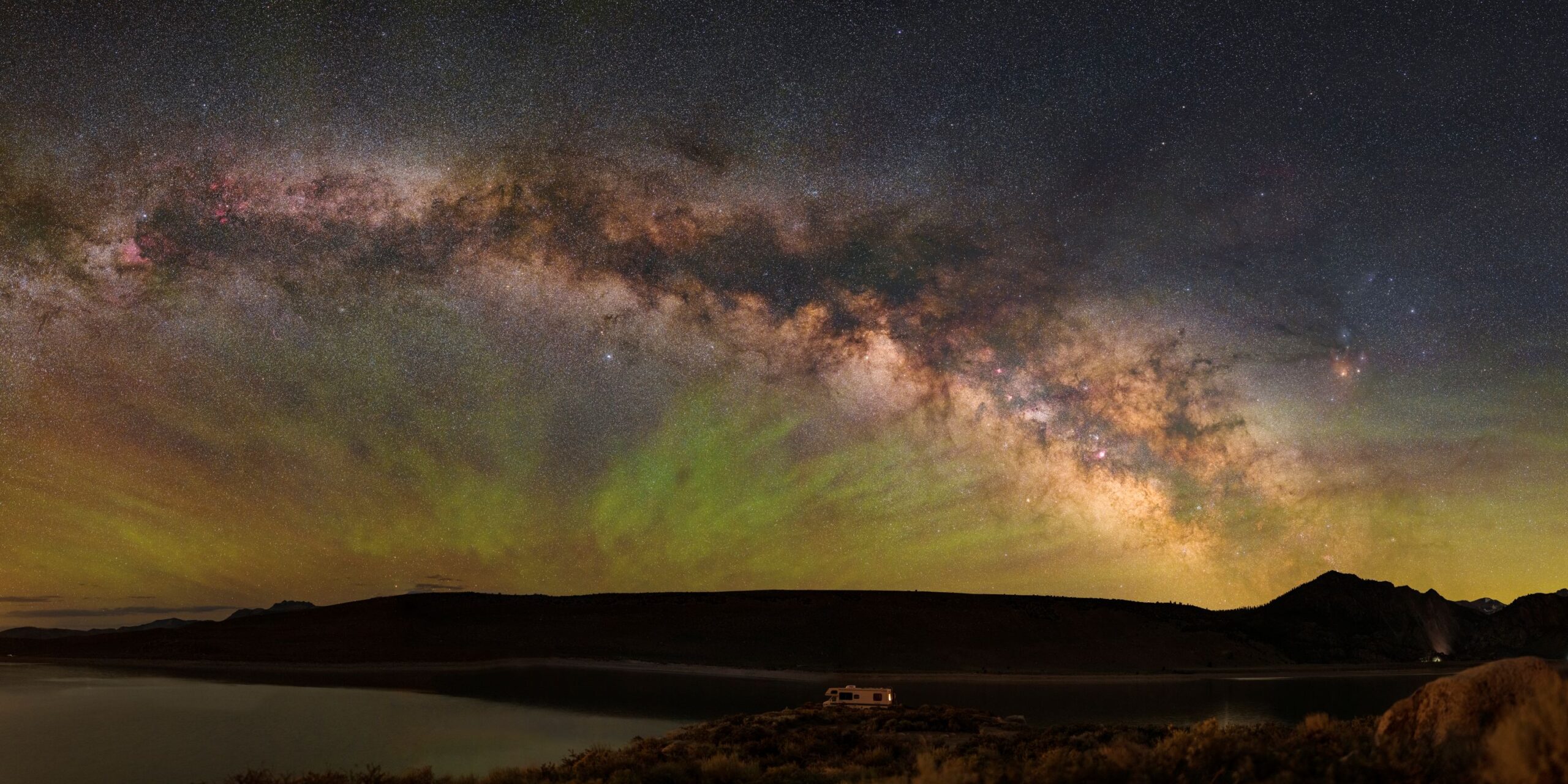 A beautiful image of the Milky way taken from Earth with a silhouette of an old school RV
