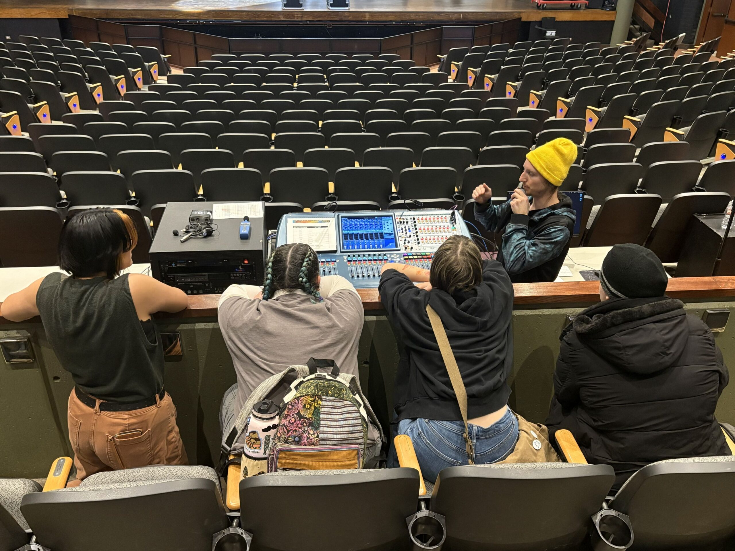 Four students sit in The Lincoln Center theater and learn about the sound system